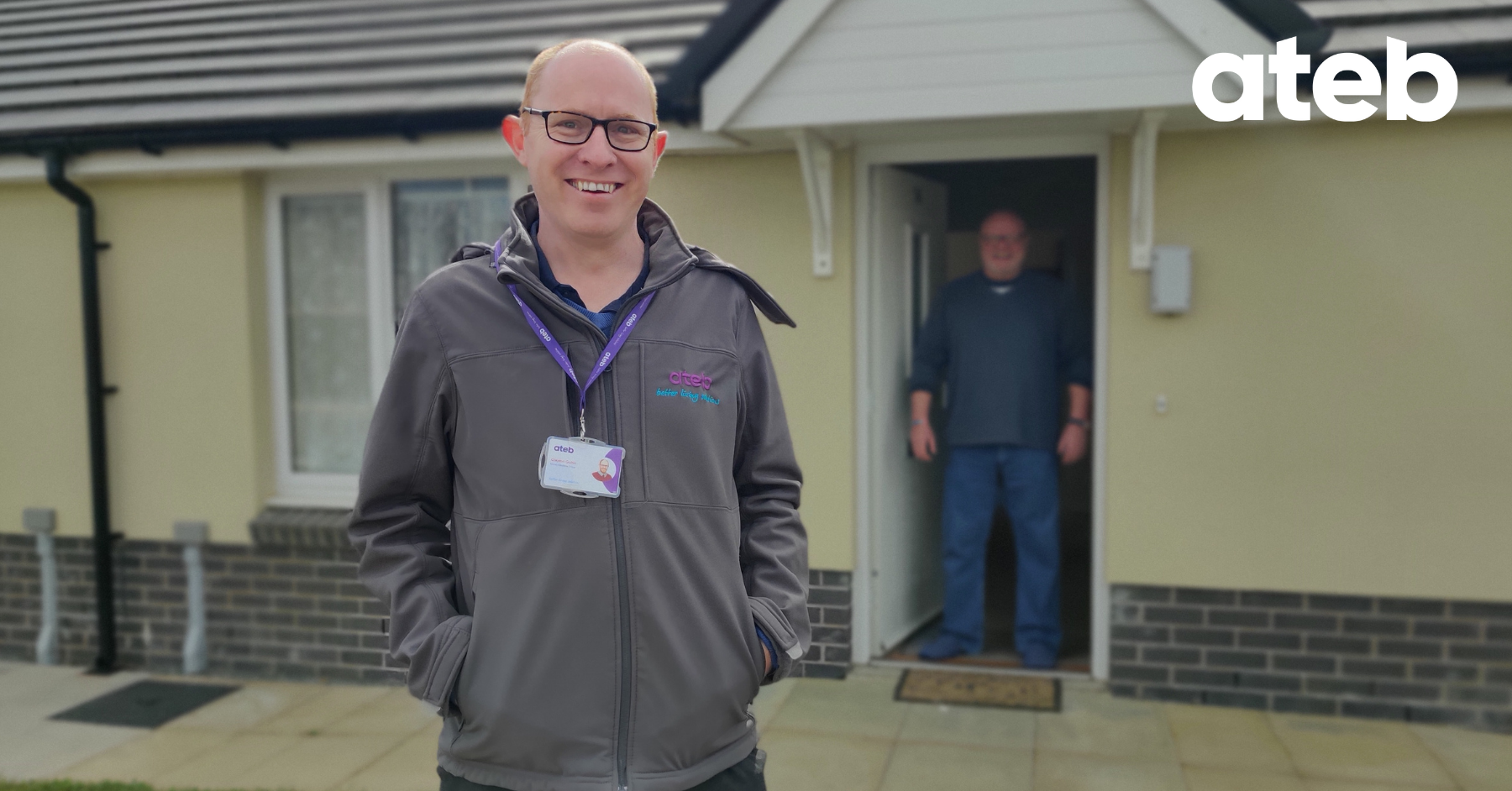 Man smiling in front of home