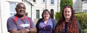 Man and two women stood in street